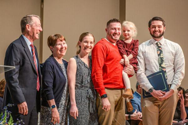 The family of Kelly McGaughey Roseberry joins Shenandoah University physical therapy student Ryan McGinniss for a photo.